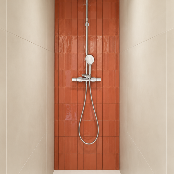Niche de douche à l'italienne avec pan de mur en faïence terracotta striée, colonne de douche chromée et parois grès cérame beige à Valras-Plage par Sophie Pico