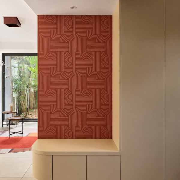 Meuble d'entrée sur-mesure beige avec banquette intégrée aux lignes arrondies et papier peint graphique terracotta dans une villa rénovée à Valras-Plage par Sophie Pico